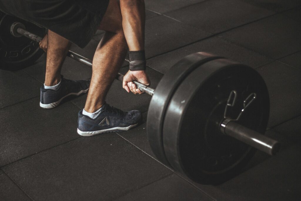 Individual lifting weights in a gym, demonstrating strength training and determination related to peptide research.